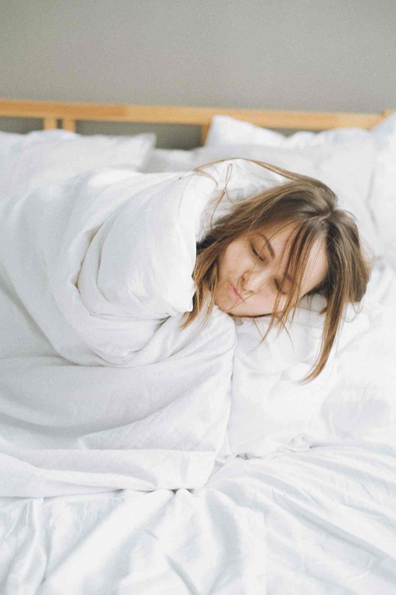 woman covered in white blanket lying on bed | mattress spring