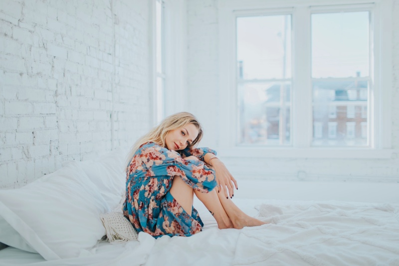 woman wearing floral dress while sitting on bed | ipedic collection