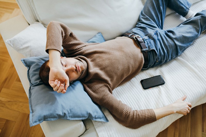 a man sleeping on a sofa | sleeping tips