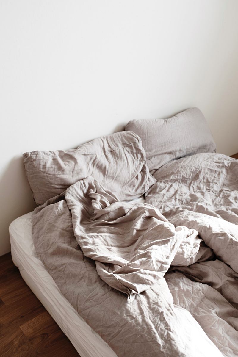gray blanket and pillows on bed | mattress on the floor