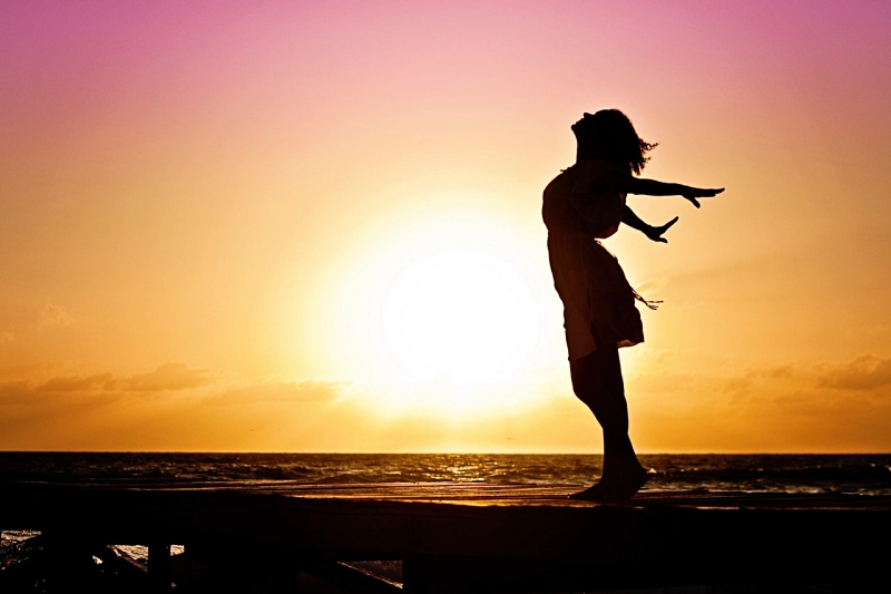 lady in beach silhouette during daytime photography | how to wake up early if you sleep late