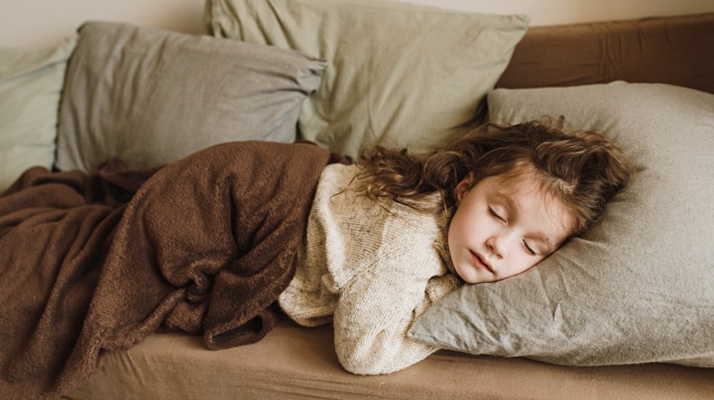 young girl sleeping in a sofa | Childhood Insomnia And How It Affects The Kids | Featured