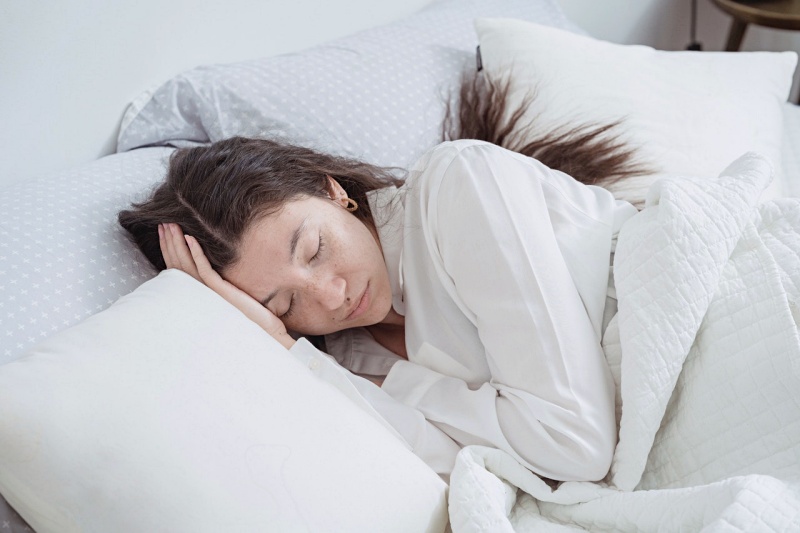 a woman asleep in a bed | bolster pillow