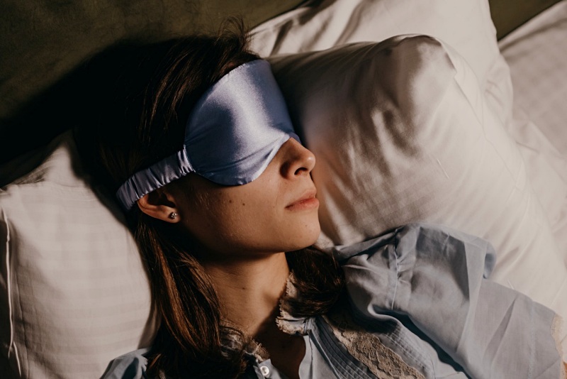 asleep woman wearing eye mask | bolster pillow