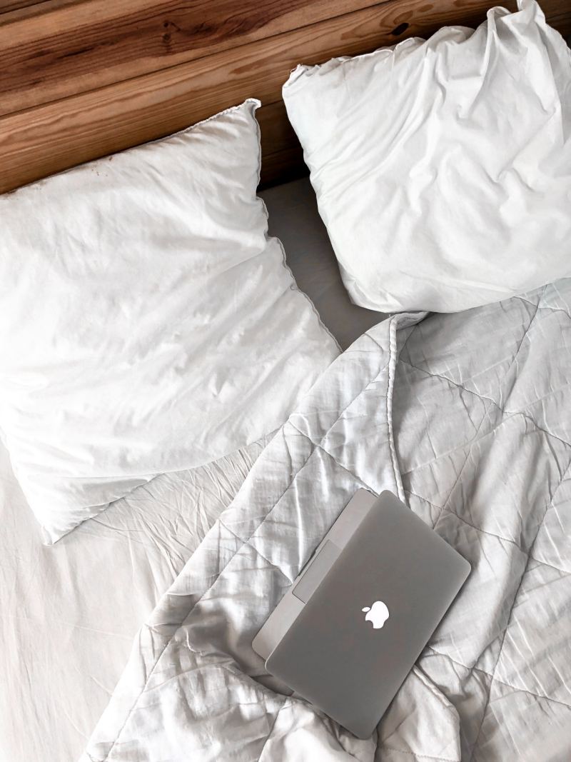 MacBook on a messy bed | comforter