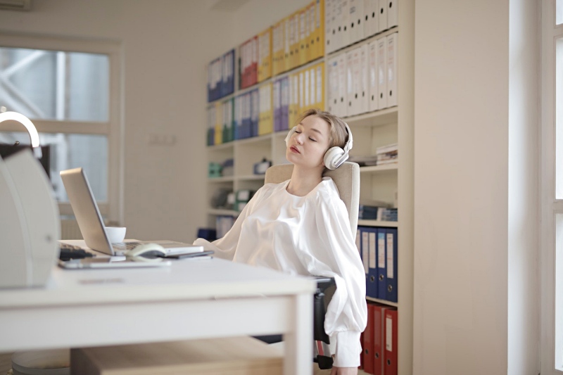 woman in white dress shirt sitting on chair | lack of sleep symptoms