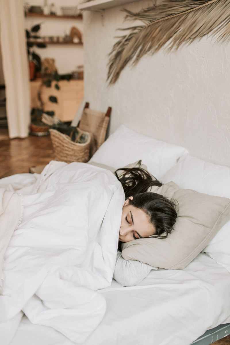 woman sleeping on a bed with white blanket | bedding