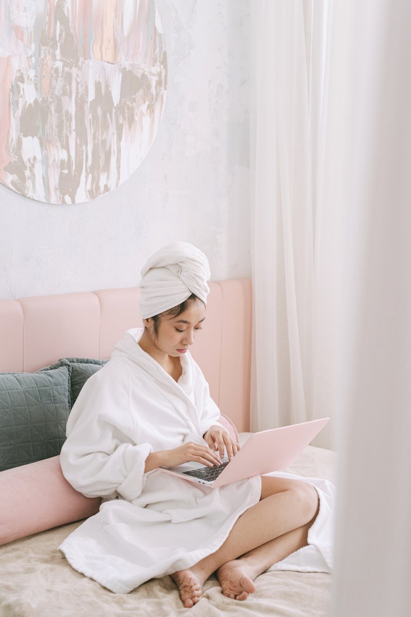 a woman in her bathrobe using a laptop | pillow protector