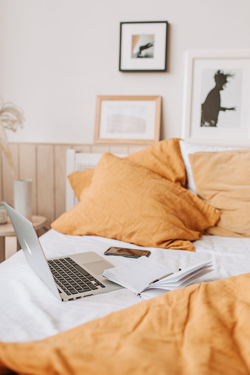 cozy bed with laptop and notebook | linen