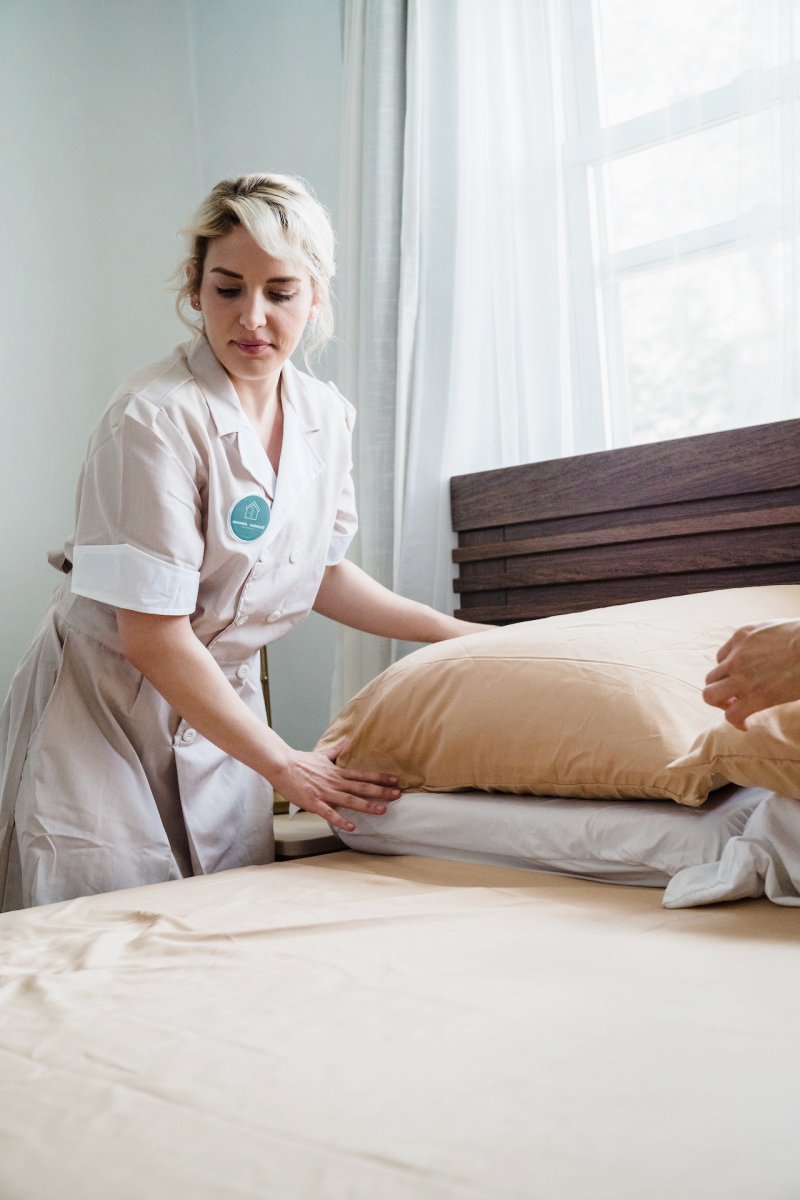 female housekeeper fixing the pillows and the bed | covers