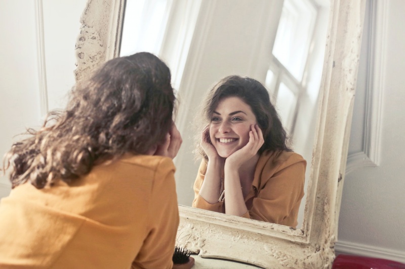 photo of woman looking at the mirror | habit