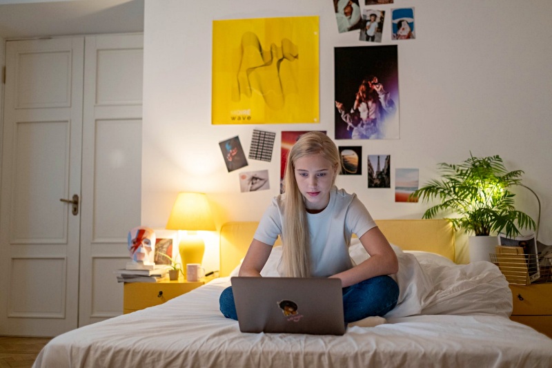 a female teenager using her laptop | bedroom