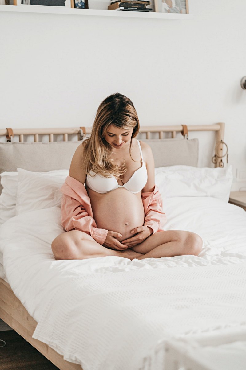 pregnant woman sitting on the bed | do pillows expire