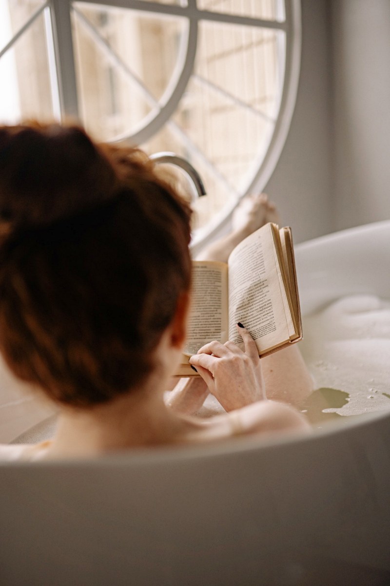 woman on bathtub while reading book | bedtime routine