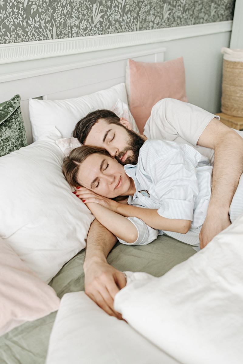 a couple hugging while resting in bed | mattress firmness guide