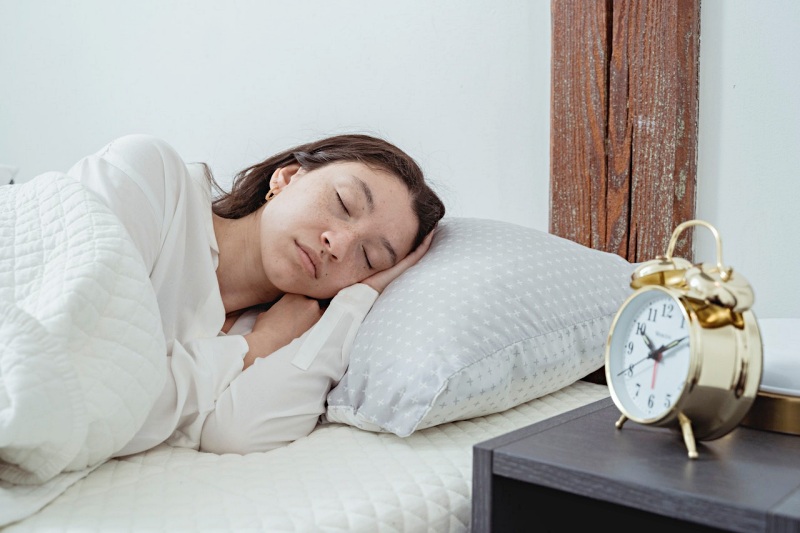 calm woman sleeping on pillow in bedroom | ideal number of hours to sleep