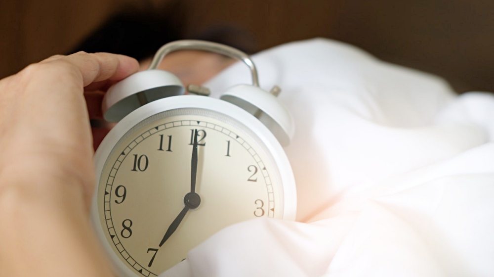 photo of person holding alarm clock | How Much Sleep Do You Need To Keep Yourself Healthy? | Featured