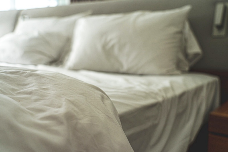 white bed with pillows | types of firmness in mattresses