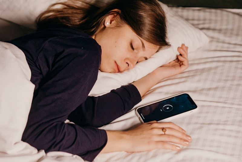 pretty woman sleeping beside her cellphone | rem sleep stage