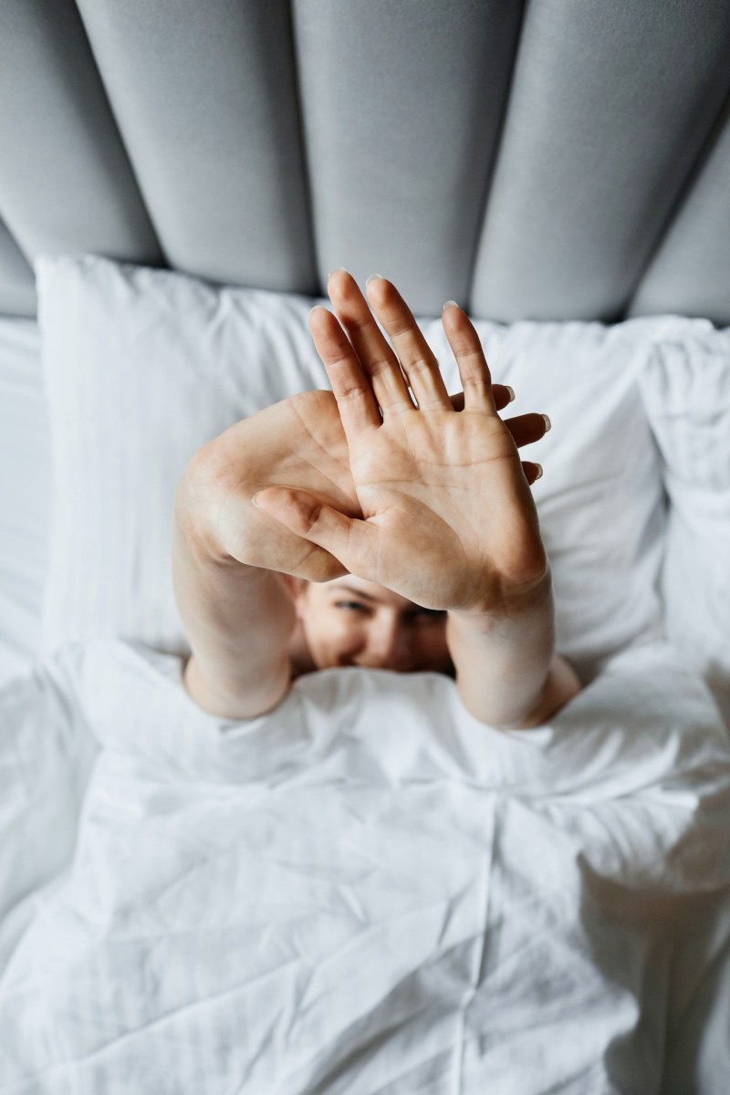 woman lying down on the bed wrapped with white blanket | stages of sleep