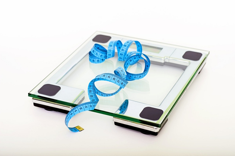 blue tape measuring on clear glass square weighing scale | energy