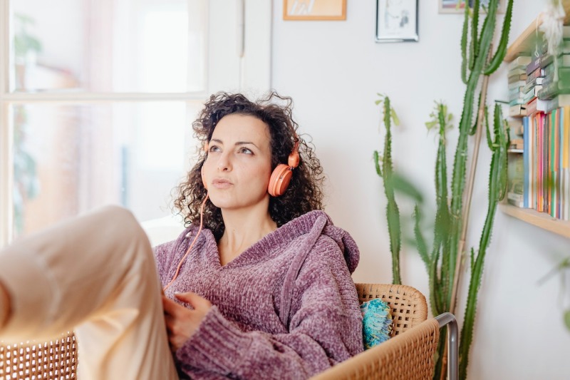 woman listening to music in living room | sound