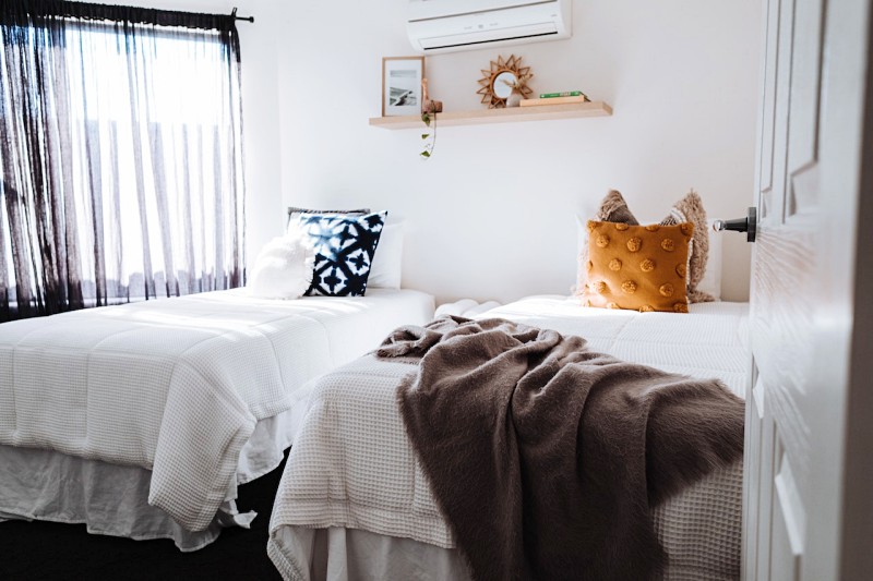 separate beds in bedroom in sunlight | mental health benefits