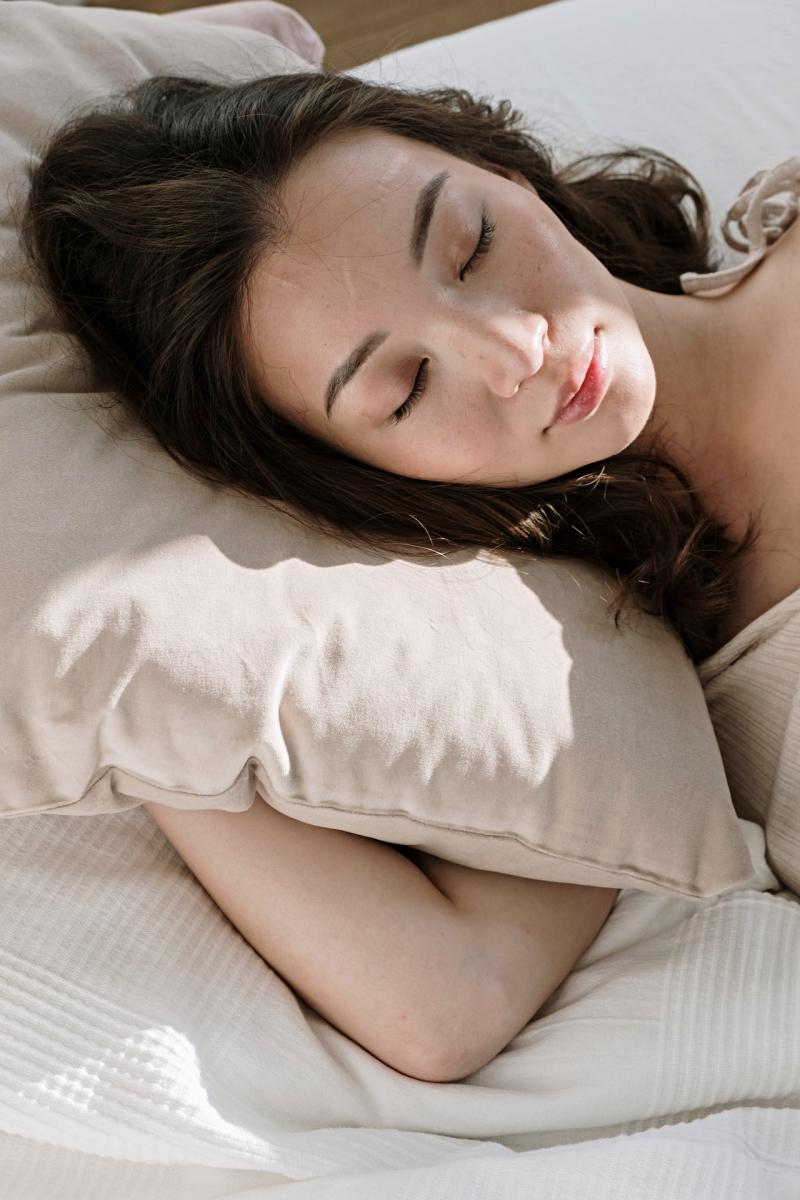 woman sleeping with pillow on bed | rem sleep