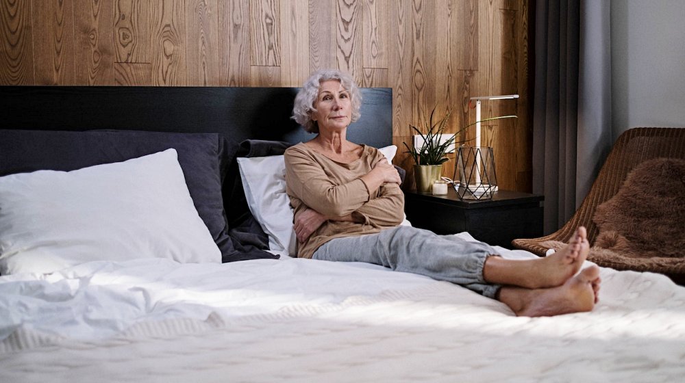 an elderly woman lying on the bed | mattress for seniors