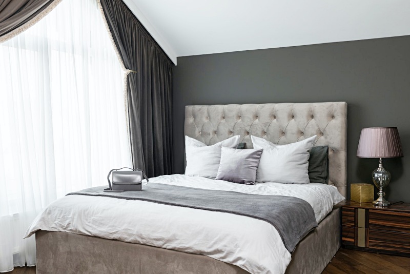 cozy bed with pillows near window | best mattresses for sleep apnea